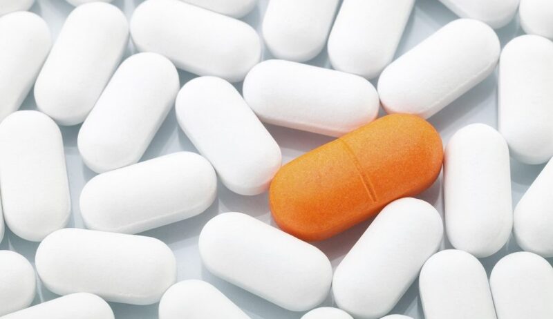 Orange pill between white ones